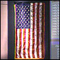 NASA image of a United States flag hanging in Mission Control. Click for "NASA RETURNS WORLD TRADE CENTER FLAG TO COMMEMORATE FLAG DAY AT NEW YORK'S AMERICAN MUSEUM OF NATURAL HISTORY" news release.